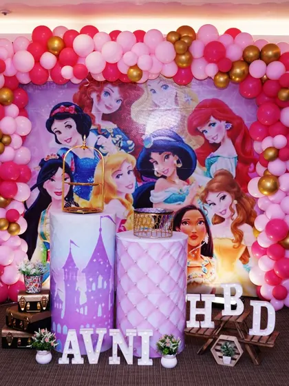 A royal gathering of Disney princesses for Avni's 7th birthday. We used a large backdrop featuring all the princesses, a pink and gold balloon frame, and themed pedestals for a truly magical party.