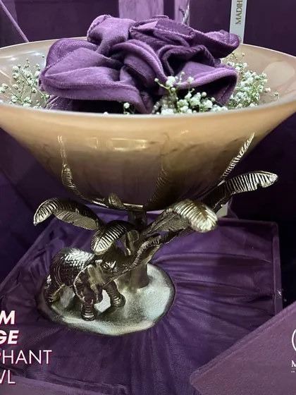 The Palm Beige Elephant Bowl, a stunning decorative piece that adds glamour to any setting. The sturdy metal base with an elephant design and a glass top seamlessly blends durability with style.