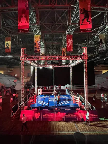A full view of the boxing setup, showing the ring, lighting truss, and surrounding spectator area. This demonstrates our capacity to host international-level boxing events.