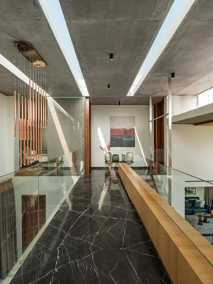 A view from the upper-level bridge in The Quarry House, looking down into the living areas and across to the other side, emphasizing the home's open, connected plan.