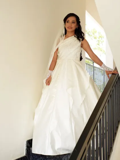 Our bride looking serene and beautiful on her wedding day in her custom-designed white gown, featuring a unique one-shoulder draped bodice.