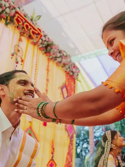 A genuine smile from the groom as a relative applies turmeric paste during the Haldi ceremony.
