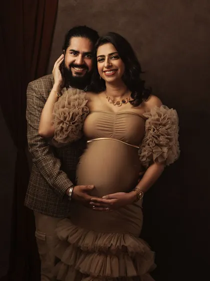 Another beautiful pose from a glamorous fine art maternity session, showcasing the intricate details of the gown and the couple's happy connection.