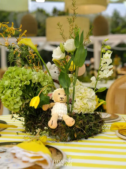 Another angle of our charming table centerpiece. A hand-crocheted lamb sits among a bed of moss and fresh flowers, adding a soft and sweet touch to the baby shower decor.