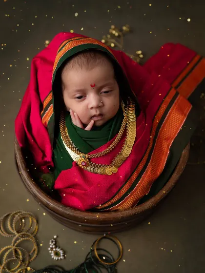 A pensive little goddess. This newborn, dressed in a traditional Maharashtrian saree wrap, looks so thoughtful and serene.