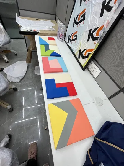 A series of smaller, colorful geometric canvas paintings laid out before installation. These can be arranged in various ways to create a custom wall feature.
