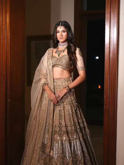 A stunning golden lehenga with silver accents, perfect for a glamorous sangeet or reception. The full skirt creates a beautiful silhouette.