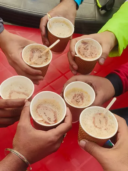 Cheers! A shot of our hands toasting with cups of coffee, a ritual that marks the end of a great ride.