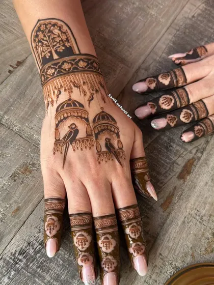 A single hand showing the bird cage motif, with delicate details on the birds and the architectural domes.