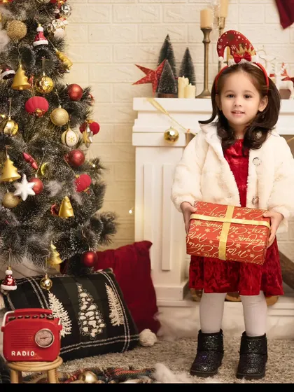 A Christmas gift for the family. This little girl is holding a present, her face full of excitement for the holiday.