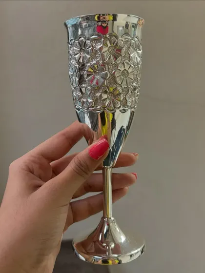 A different angle of our floral-patterned silver wine glass. The polished finish and detailed texture make every sip feel like a celebration.