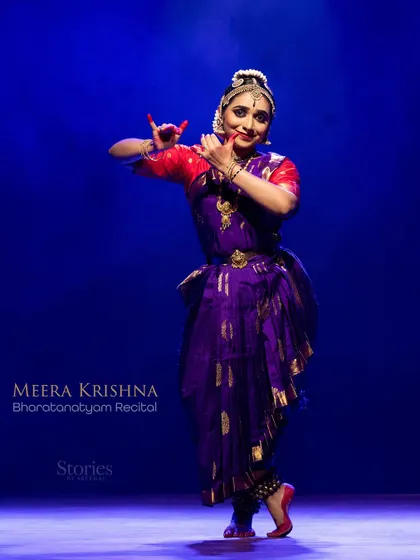 A full-stage view of Meera Krishna's recital, showing her presence against the simple, effective backdrop.