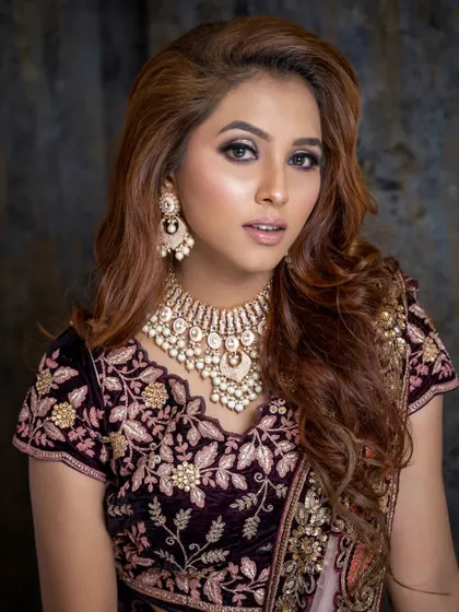 This glamorous look features rich, voluminous waves that complement the heavy velvet lehenga. It's a perfect hairstyle for a winter wedding or reception.