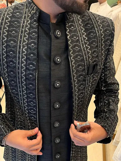 A close-up shot of the intricate silver embroidery and custom buttons on the black bandhgala jacket.