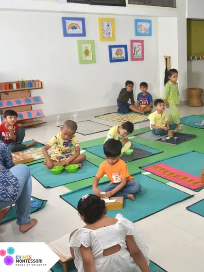 A wide view of our classroom shows children working independently on their mats. This is the peaceful, productive hum of a Montessori environment.