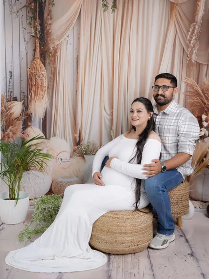 A full-length portrait of a couple in our boho-themed studio. This shot showcases the complete look, from the styling of the set to the couple's relaxed interaction.
