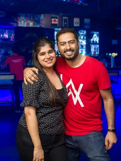 Posing in front of the bar, the heart of the action. My bartenders are always ready to serve up your favorite drink.