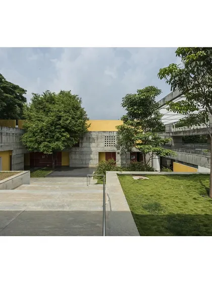 The IIM Sports Center, designed as a non-building that emerges from the green landscape. The structure is planned on two levels, responding to the site's contours and preserving existing trees.