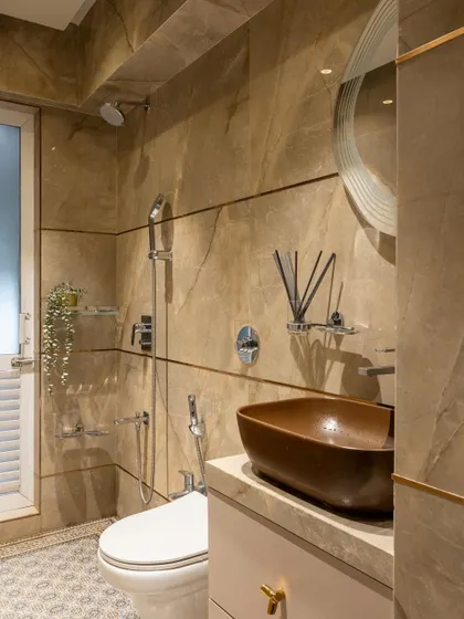A bathroom that blends natural textures with modern fixtures. The brown marble walls, a unique vessel sink, and patterned floor tiles come together to create a warm and sophisticated retreat.