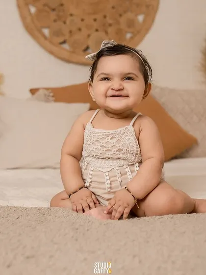 A sweet baby girl with the cutest smile, captured in our cozy boho bedroom set.