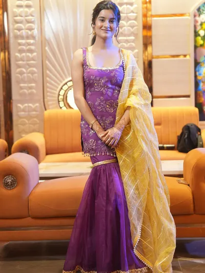 A client looking lovely in a custom purple sharara suit with a contrasting yellow dupatta. This outfit was part of her wedding wardrobe for her cocktail event.