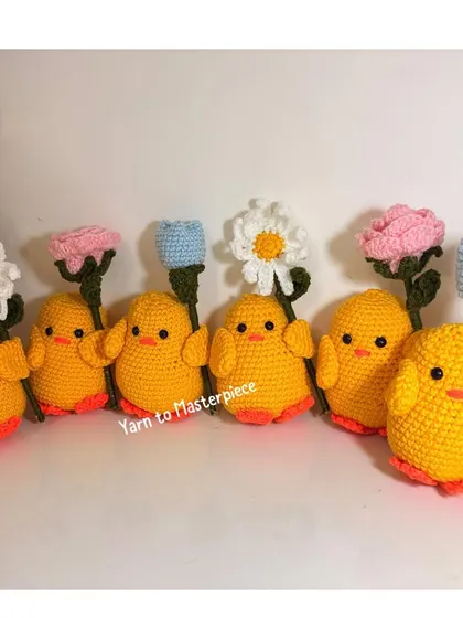 A whole flock of my crochet chicks, each holding a different flower like a daisy, rose, or tulip. They look so cute together!