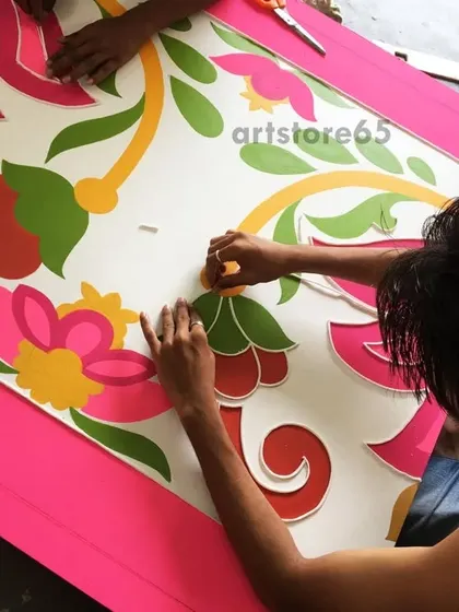 Our artists are seen here carefully placing the clay outlines for a large floral design. This is a crucial step where the pattern is defined before the mirrors and colors are added.