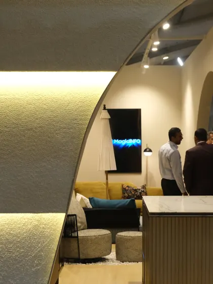 A view from within the booth, looking out through the arched openings. The design creates a feeling of being in a refined, gallery-like space, separate from the hustle of the main exhibition hall.