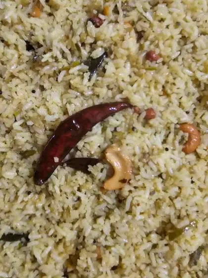 A close-up of our flavorful pulao, garnished with a whole dried red chili and cashews.