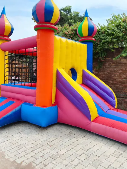 This colorful bouncy castle features unique onion-dome turrets and safety netting on the walls of the jumping area.