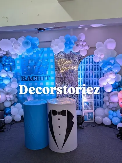 The Boss Baby themed decoration illuminated with spotlights. The lighting highlights the shimmering backdrop and adds a professional touch to your at-home party.