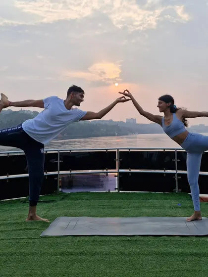 A partner version of Natarajasana (Dancer Pose) at sunset. This shows how we can support each other to find deeper expressions of familiar poses.