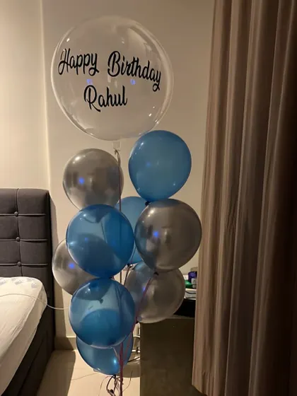 A simple and stylish birthday bouquet for Rahul. This arrangement includes a personalized clear bubble balloon paired with classic blue and silver balloons, perfect for a surprise at home.