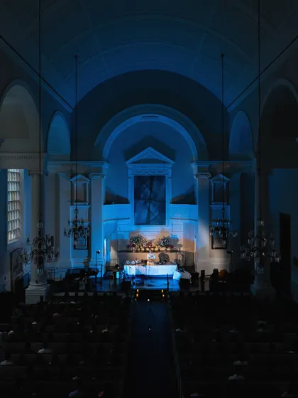 A wide shot of the audience and stage at All Souls NYC, highlighting the grand yet intimate feel of the venue.
