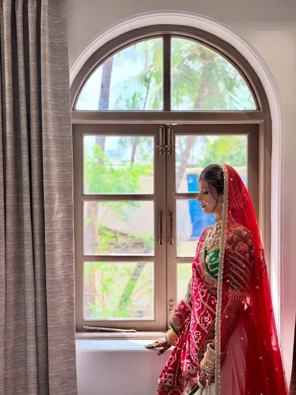 A candid shot of the bride by the window, where natural light illuminates her soft and elegant makeup.