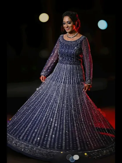 A full-length shot of the bride twirling in her magnificent sequined blue gown, capturing the dress's movement and sparkle.