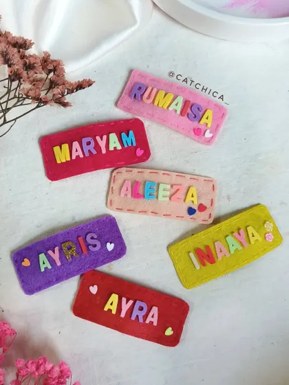 Our felt name clips are available in a variety of vibrant colors. Here you can see clips made for Maryam, Rumaisha, Aleeza, Inaaya, Ayra, and Ayris.