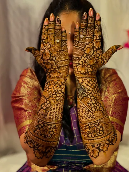 A traditional bridal design featuring lotus flowers and intricate jaali (net) work. The peek-a-boo pose adds a touch of playful charm.