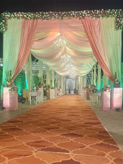 This grand entrance walkway is designed for a truly royal feel. Draped in soft peach and cream fabrics and illuminated by elegant chandeliers, it creates a warm and inviting passage for guests.