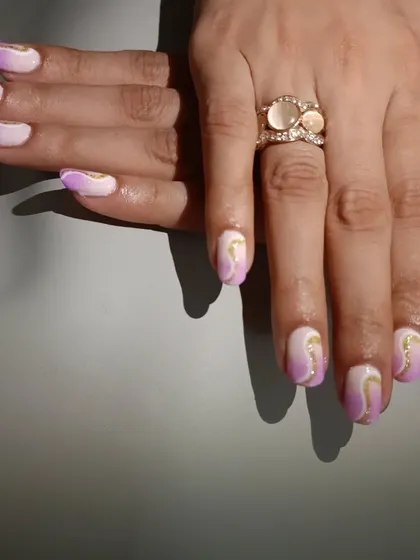 A different angle of the lavender ombre nails, showing how the gold swirls catch the light.