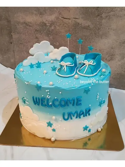 Welcome baby Umar! This blue and white ombre cake is decorated with fondant clouds and tiny blue baby booties, creating a dreamy sky theme for a newborn celebration.