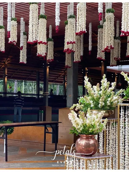 The entrance area with metal stands and urli flower decor, a grand yet elegant setup for an intimate event.