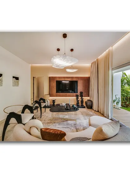 A contemporary living room with a sculptural sofa and unique art pieces. The space opens up to a lush garden, creating a seamless indoor-outdoor connection that is perfect for modern living.