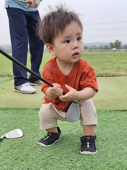 A future champion in the making. This toddler looks ready to take his first swing, showing that the love for golf can start at any age.