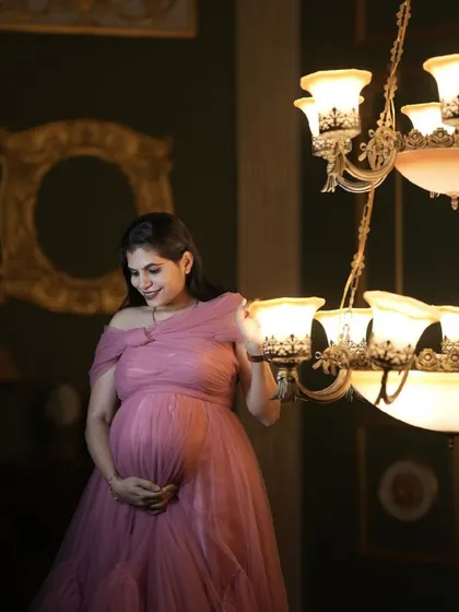 A glowing mother-to-be in a custom pink gown, a perfect choice for a memorable photoshoot.