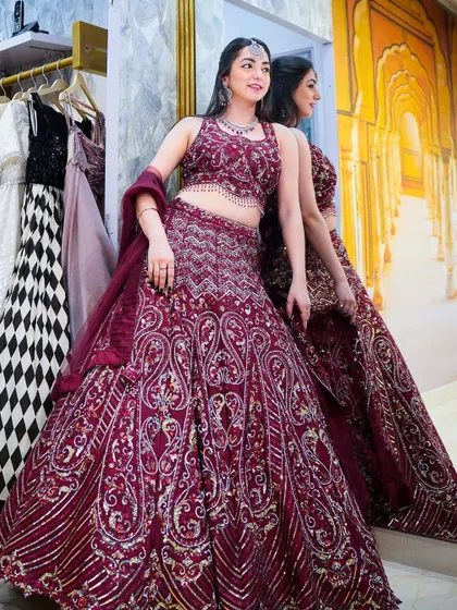 A stunning maroon lehenga that's perfect for a bride or bridesmaid. The rich color and heavy embroidery give it a royal and timeless feel.
