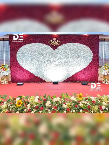 A wide view of the magnificent red and white rose wall, designed as a reception stage backdrop. The sheer scale of the floral installation creates an unforgettable visual impact.