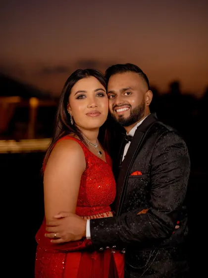 A classic couple portrait of Monika and Mukul, smiling for the camera on their reception night.