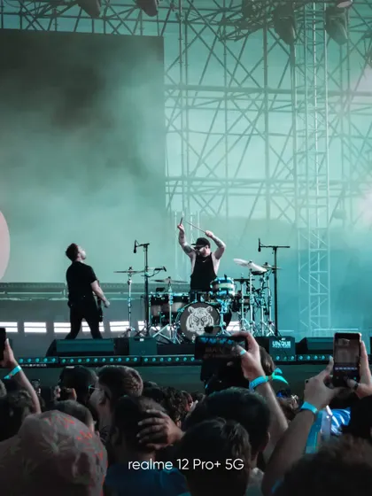A shot from the Lollapalooza music festival, capturing the drummer in action from the crowd's perspective. This photo, taken with the realme 12 Pro+, shows the camera's zoom capability in a live event setting.