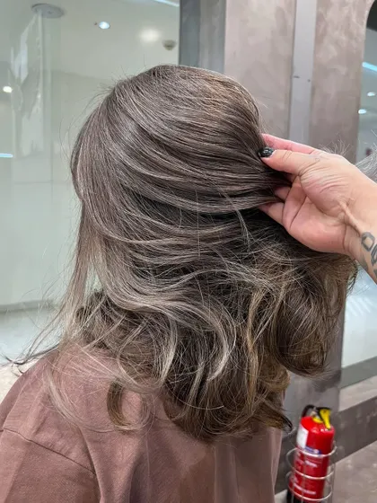A close-up on a beautiful ash hair color, showing the blend of cool tones and the healthy texture of the hair.